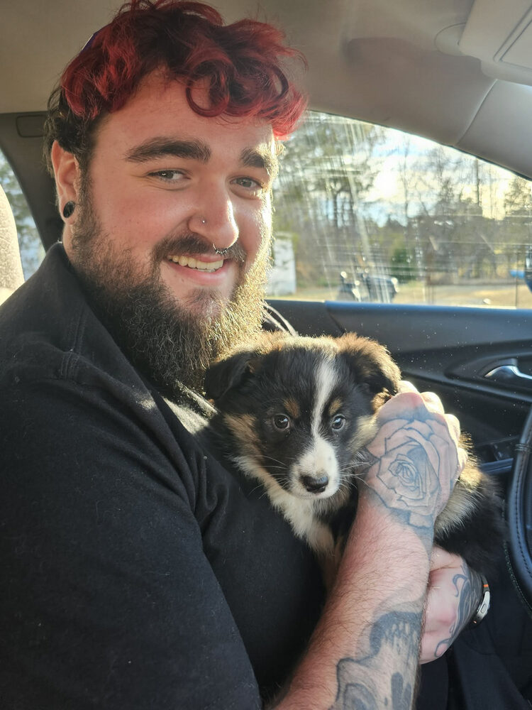 Groomer apprentice holding a rescued puppy