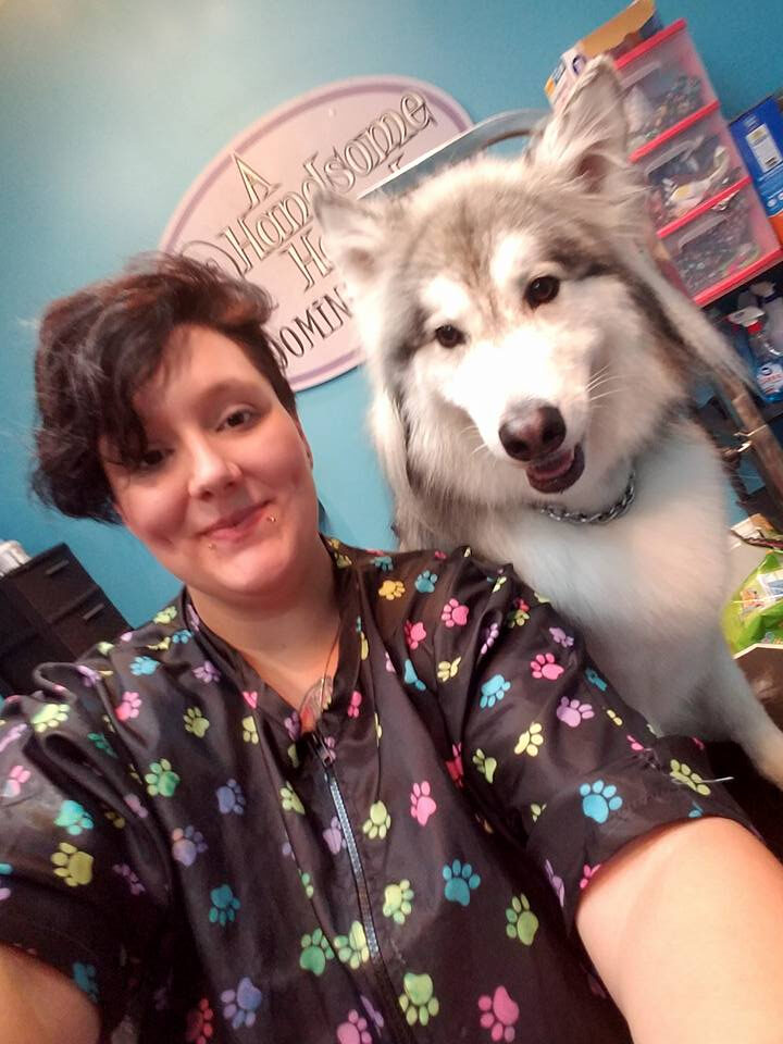 Owner and lead groomer with a husky puppy